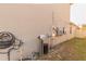 Exterior view of water filtration system, electric meter, and various utilities mounted on the home's stucco wall at 2778 Sunkissed Dr, St Cloud, FL 34771