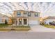 Inviting two-story home featuring a covered porch, a driveway, and fresh landscaping at 2778 Sunkissed Dr, St Cloud, FL 34771