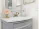 Gray vanity with a white countertop, a modern faucet, decorative mirror and a floral arrangement at 2818 Roccella Ct, Kissimmee, FL 34747