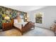 Bedroom with patterned accent wall, warm wood accents, and abundant natural light at 2818 Roccella Ct, Kissimmee, FL 34747