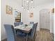 Dining room features a modern table set for six with pendant lighting and light wood-look floors at 2818 Roccella Ct, Kissimmee, FL 34747