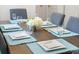 Table set for six with square plates, elegant glassware and a white floral centerpiece at 2818 Roccella Ct, Kissimmee, FL 34747