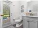 Bathroom with a gray vanity, decorative mirror and a door leading to an outdoor pool area at 2818 Roccella Ct, Kissimmee, FL 34747
