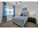 Bedroom with gray platform bed, blue bedding, and window with curtains at 3055 Prospect Trl, St Cloud, FL 34771