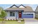 Two-story Craftsman home with red door, blue garage, and landscaped yard at 3055 Prospect Trl, St Cloud, FL 34771