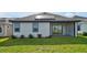 House back view, featuring a covered patio and solar panels at 3055 Prospect Trl, St Cloud, FL 34771