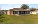 Backyard featuring a screened porch with a beautiful green lawn at 3219 Sawgrass Creek Cir, St Cloud, FL 34772