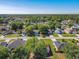 This aerial view shows a neighborhood with mature trees and well-maintained homes at 438 Jay Ct, Kissimmee, FL 34759
