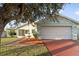 House exterior featuring a light teal color, attached garage, and well-manicured lawn at 511 Cardinal Dr, Kissimmee, FL 34759