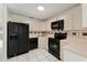 Kitchen features black appliances and light-colored cabinets at 511 Cardinal Dr, Kissimmee, FL 34759