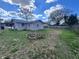 Spacious backyard with a small building in the background and a pile of brush at 589 Duncan E Cir, Auburndale, FL 33823