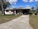 Charming single-story home featuring a carport and a concrete driveway at 589 Duncan E Cir, Auburndale, FL 33823