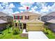 Two-story house with attached garage, landscaping, and driveway at 7638 Oakmoss Loop, Davenport, FL 33837