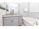 Bathroom with granite vanity, bathtub and large mirror at 7638 Oakmoss Loop, Davenport, FL 33837