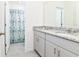 Bathroom with granite countertop and dual sinks at 7638 Oakmoss Loop, Davenport, FL 33837