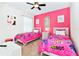 Bedroom with two twin beds, pink walls and art at 7638 Oakmoss Loop, Davenport, FL 33837