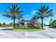 Ornate entrance to the community with palm trees and landscaping at 7638 Oakmoss Loop, Davenport, FL 33837
