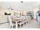 Farmhouse-style dining table with eight chairs, adjacent to kitchen at 7638 Oakmoss Loop, Davenport, FL 33837