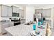 Granite kitchen island with seating, gray cabinets, stainless steel appliances at 7638 Oakmoss Loop, Davenport, FL 33837