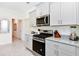 Modern kitchen with gray cabinets, granite countertops, and stainless steel appliances at 7638 Oakmoss Loop, Davenport, FL 33837
