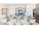 Modern kitchen boasts granite island with seating, gray cabinets and stainless steel appliances at 7638 Oakmoss Loop, Davenport, FL 33837