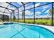 Relaxing screened-in pool and spa with a view of lush greenery at 7638 Oakmoss Loop, Davenport, FL 33837