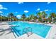 Large, inviting pool with plenty of lounge chairs and palm trees at 7638 Oakmoss Loop, Davenport, FL 33837