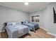 A well-lit secondary bedroom featuring two beds, neutral walls, and laminate wood-look flooring at 7658 Whisper Way # 202, Reunion, FL 34747