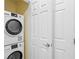 Stacked washer and dryer in an enclosed laundry area near a closet at 7658 Whisper Way # 202, Reunion, FL 34747