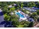 Aerial view of a community pool, tennis courts, playground, and lush landscaping at 7658 Whisper Way # 202, Reunion, FL 34747