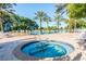 Community pool with a hot tub, lounge chairs, and palm trees at 7658 Whisper Way # 202, Reunion, FL 34747