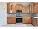 Well-equipped kitchen with stainless steel appliances, wood cabinets, and tile backsplash at 9786 Lake District Ln, Orlando, FL 32832