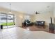 Bright living room with tile and wood flooring, ceiling fan, and sliding glass doors to the backyard at 9786 Lake District Ln, Orlando, FL 32832