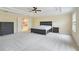 Spacious main bedroom with a tray ceiling, an ensuite bathroom, and neutral carpet at 9786 Lake District Ln, Orlando, FL 32832