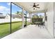Screened in back porch with a fan, table, chairs and beautiful backyard view at 9786 Lake District Ln, Orlando, FL 32832