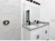 Bathroom with white dual vanity, granite countertop, black fixtures, and a tiled shower at 1022 Mack Ave, Orlando, FL 32805