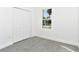 This carpeted bedroom features neutral walls and trim, a window and closet storage at 1022 Mack Ave, Orlando, FL 32805