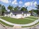 Low angle view of the property with an expansive lawn, sidewalk, and manicured landscape at 1022 Mack Ave, Orlando, FL 32805