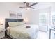 King bed, ceiling fan, and large window at 1118 Park Ridge Cir, Kissimmee, FL 34746