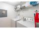 Well-equipped laundry room with washer, dryer, and shelving at 1118 Park Ridge Cir, Kissimmee, FL 34746