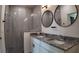 Bathroom featuring double sinks, granite counters, framed mirrors, and glass enclosed shower at 1315 Congo Dr, Kissimmee, FL 34759