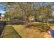 Large backyard with grassy area, mature trees, and a privacy fence at 1320 Moss Creek Ln, Davenport, FL 33836