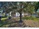 Expansive backyard with a large tree providing shade and a grassy area at 1320 Moss Creek Ln, Davenport, FL 33836