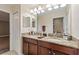 Double vanity bathroom with granite countertops and large mirror at 1320 Moss Creek Ln, Davenport, FL 33836