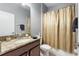 Bathroom with granite countertop, single sink, and gold shower curtain at 1320 Moss Creek Ln, Davenport, FL 33836