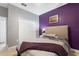 Bedroom with purple accent wall and striped bedding at 1320 Moss Creek Ln, Davenport, FL 33836