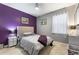 Bedroom with purple accent wall and striped bedding at 1320 Moss Creek Ln, Davenport, FL 33836