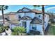 Two-story home with tile roof, white exterior, and a two-car garage at 1320 Moss Creek Ln, Davenport, FL 33836