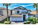 Two-story home with tile roof, white exterior, and a two-car garage at 1320 Moss Creek Ln, Davenport, FL 33836