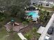 Community pool surrounded by palm trees, a playground, and greenery at 1765 Petiole Pl, Kissimmee, FL 34744